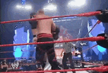 two men are wrestling in a wrestling ring with a referee and a sign that says ' spike ' on it .