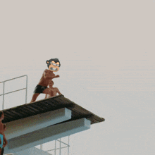 a man is jumping into a pool with a guitar on his back