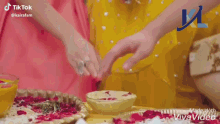 a woman in a pink dress is sitting next to another woman while looking at her phone .