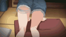a girl in shorts is sitting on a red cushion with her legs crossed
