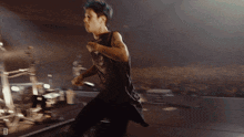 a man in a black tank top is running on a stage