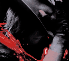 a person holding a knife over their face with blood coming out of it