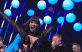 a woman in a black top is being lifted by a man in a blue shirt