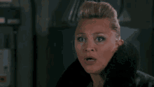 a woman with a surprised look on her face wearing a fur coat