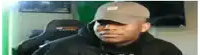a man wearing a hat is sitting in a chair in front of a green screen .
