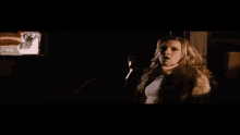 a woman in a dark room with her mouth open