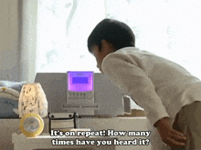 a boy is looking at a device that says it 's on repeat how many times have you heard it ?