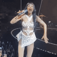 a woman singing into a microphone with her mouth wide open