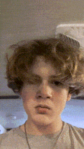 a young man with a comb in his hair is making a funny face