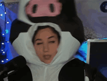 a woman is wearing a cow costume with a pig on top of her head .
