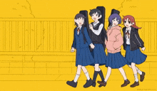 a group of girls in school uniforms are walking down a sidewalk