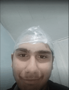 a man wearing a plastic bag on his head looks at the camera