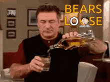 a man is pouring a glass of whiskey from a bottle in a living room .