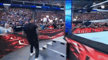 a man is walking down stairs in a wrestling ring .