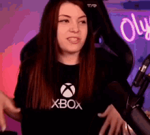 a woman is sitting in front of a microphone wearing a xbox shirt .