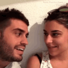 a man and a woman are looking at each other with their eyes closed .