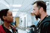 a man and a woman are looking at each other and the man is asking the woman if she is ok