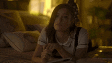 a woman laying on a bed with a book and a pen