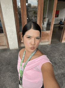 a woman in a pink top has a lanyard around her neck that says ' lg '
