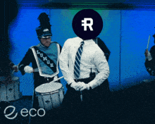 a man in a suit is playing drums in a marching band with a circle with a letter r on it