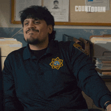 a man in a police uniform is smiling in front of a bulletin board with the word countdown on it