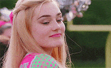 a close up of a woman 's face wearing a pink and green polka dot shirt .