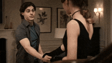 a man and a woman are holding hands in a room