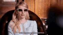 a woman wearing sunglasses and a blue jacket is sitting in a chair and says well , that sure sounds suspicious .