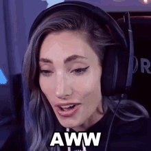 a woman wearing headphones says " aww " in a black box