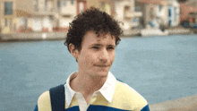 a man with curly hair wearing a striped shirt