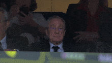 a man in a suit and tie is sitting in the stands