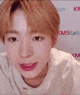 a close up of a person 's face with a white shirt on and a pink lip .