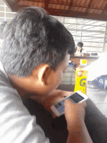 a man is using a cell phone in front of a bottle of gatorade