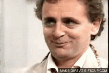 a man in a suit and tie is smiling at the camera .