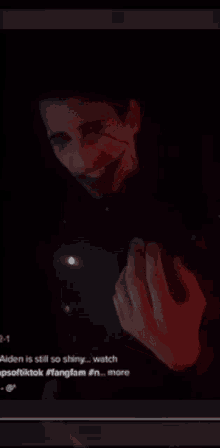 a man with blood on his face is holding a light in his hand .