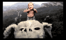 a boy standing on top of a stuffed animal