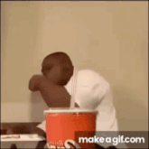 a man is sitting at a table with a cup of soda and a straw .