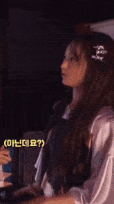 a girl with a hair clip in her hair is standing in the dark