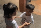 a boy and a girl are holding hands and the boy is wearing a shirt that says ' sensible head ' on it