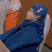 a man wearing a blue hat with a bone on it
