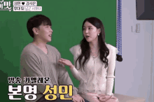 a man and a woman are sitting in front of a green screen with korean writing