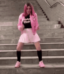 a girl with pink hair is dancing on a set of stairs .