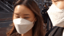 a man and a woman wearing face masks with the man 's mask having a letter o on it