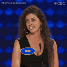a woman with a name tag that says jojo stands in front of a microphone