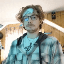 a man wearing glasses and a headband with the letter s on it