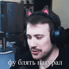 a man wearing headphones with a cat ear headband says " фу блять натура "