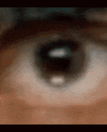 a close up of a person 's eye with a blurry background