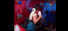 a man and a woman are dancing in a room with balloons and a tv logo in the background
