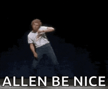 a man is dancing on a stage with the words `` allen be nice '' written on the bottom .