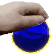 a hand is holding a blue ball with a yellow ring around it .